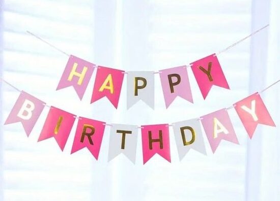 Virtene "Happy Birthday" krāsaini burti rozā toņos. 